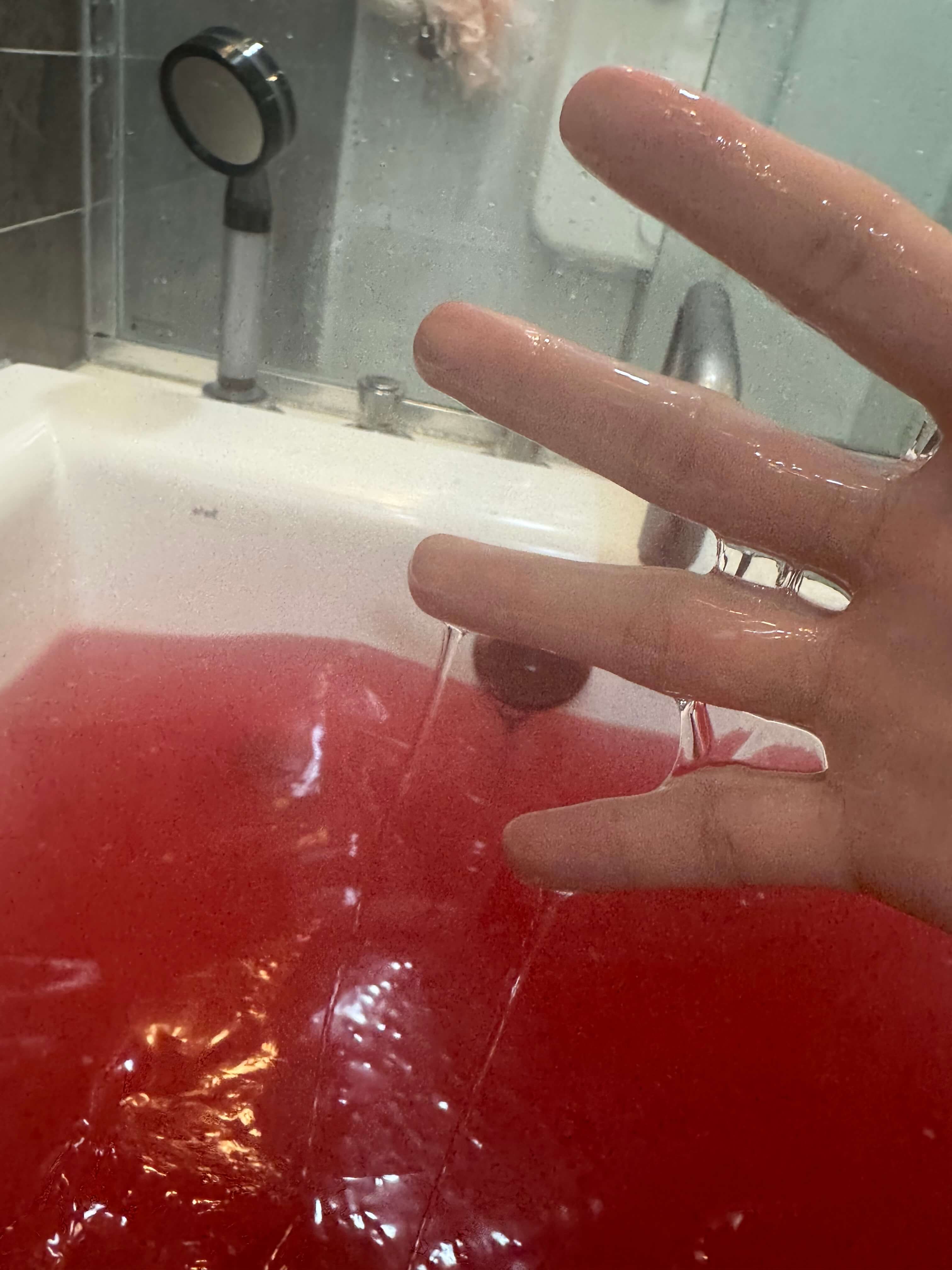 Hand reaching into a jelly bath with a blurred background
